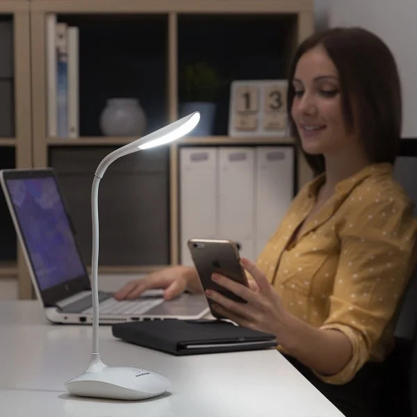 En dame som jobber på et kontor med bordlampe på