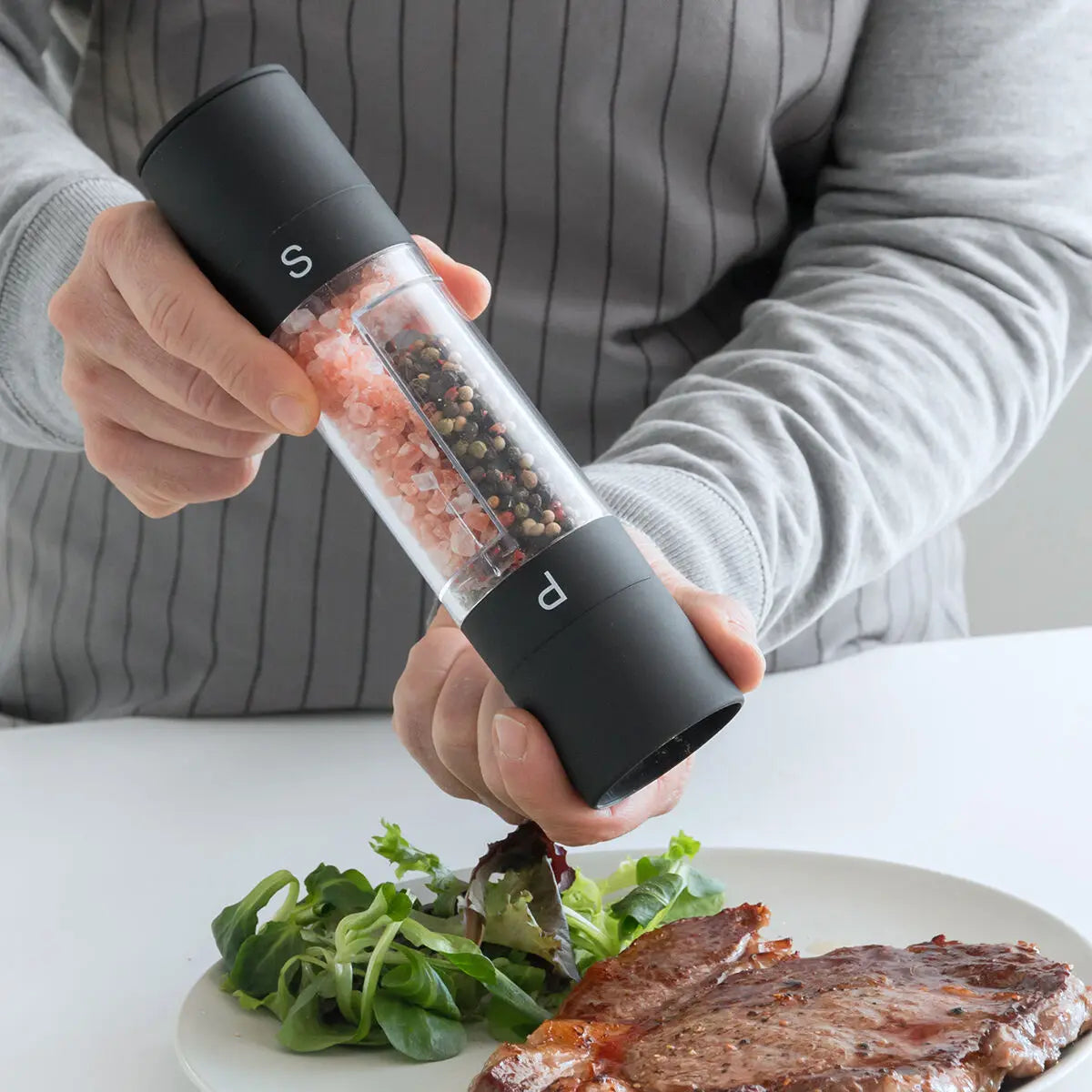 En mann som bruker en innovativ salt- og pepperkvern hjemme