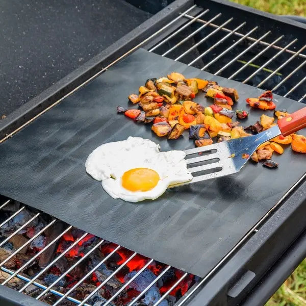 Grillmatte brukt ute på en grill med et egg og grønnsaker på