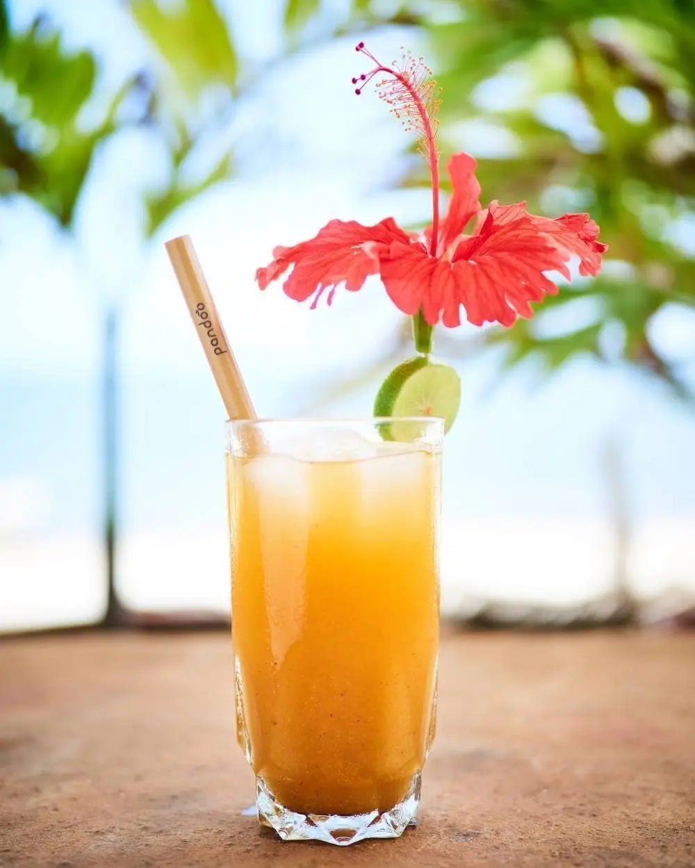 Bambussugerør i en drink på en strand