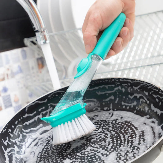 En mann som vasker en stekepanne med den smarte oppvaskbørsten