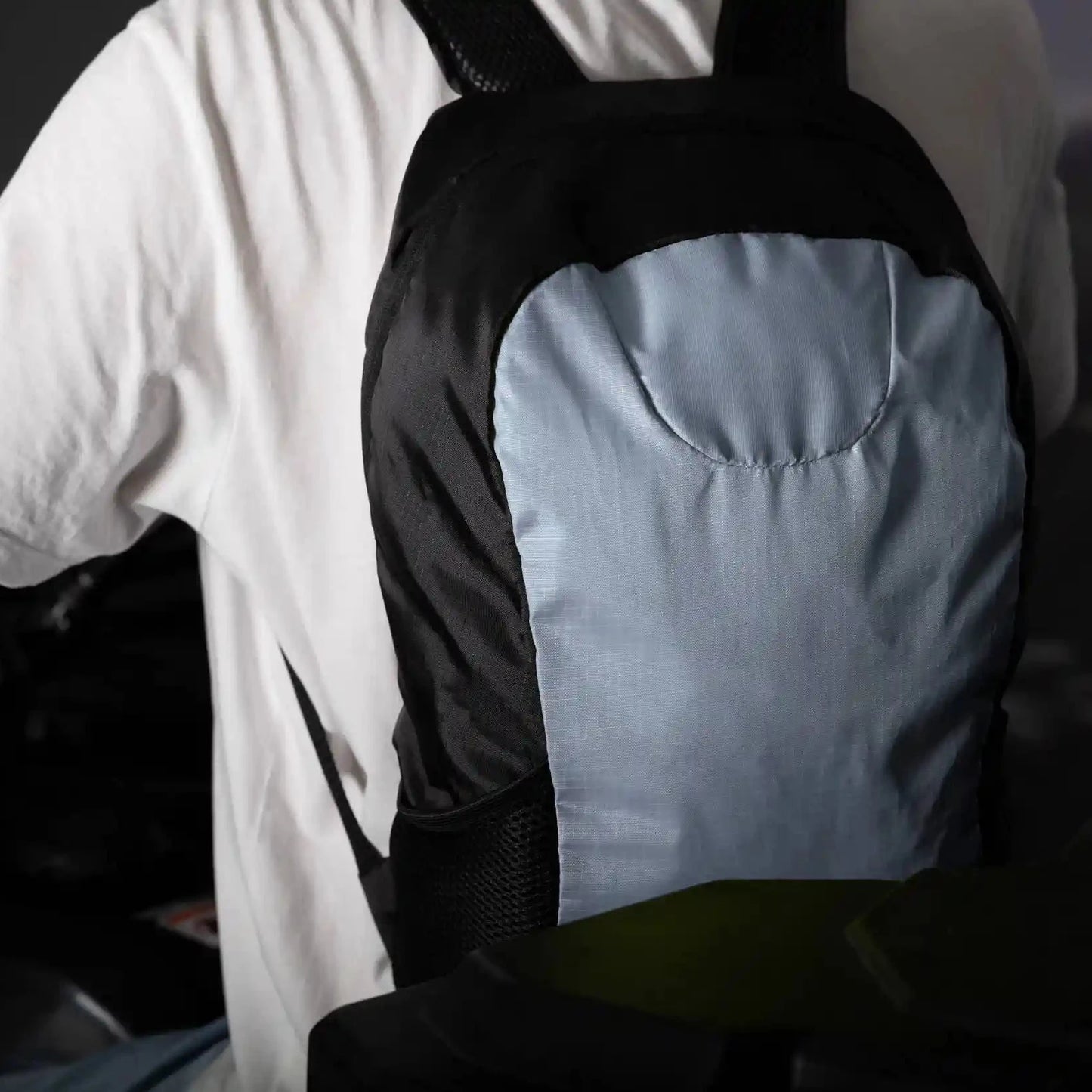 En mann med ryggsekken i grå og svart farge på ryggen
