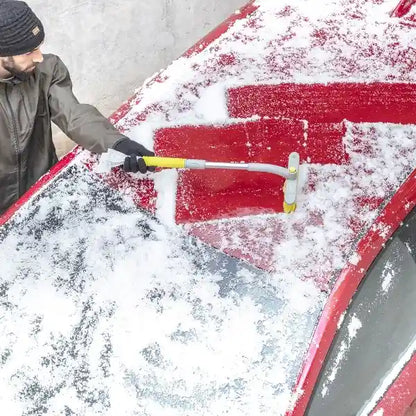 En mann fjerner snø fra bilen